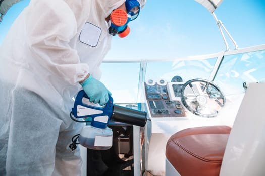 antiseptic treatment. sanitary cleanliness. Professional in uniform disinfects the yacht