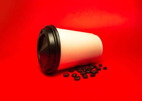 paper cup of coffee with beans on a red background.