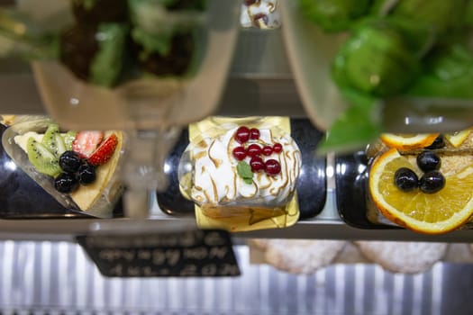 dessert on a cooking showcase. cake with berries on a black plate