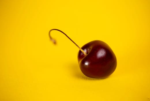 ripe cherries close-up on a yellow background.