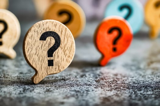 Group of wooden question marks on table. Generative AI.