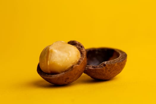 delicious and high-calorie macadamia nut on a yellow background.