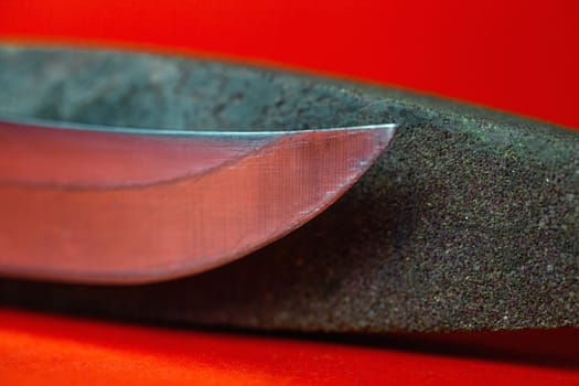 knife sharpening and stone for sharpening knives on a red background