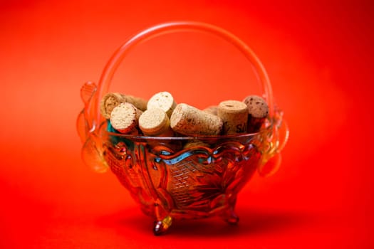 wine corks in a glass vase on a red background