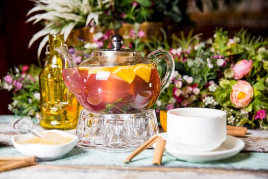 strawberry berry tea with orange in a transparent kettle