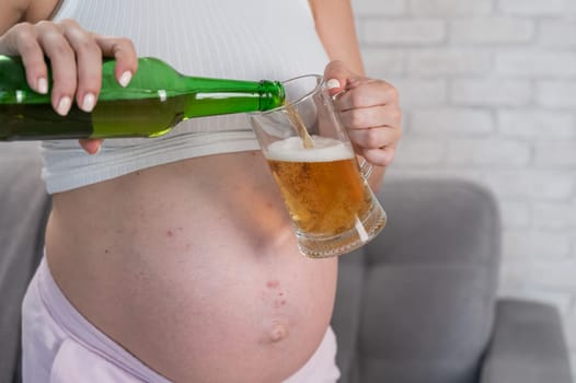 Faceless pregnant woman pouring beer into a glass