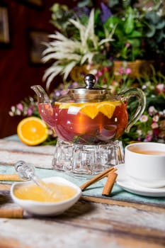 transparent kettle with fruit tea, honey with cinnamon