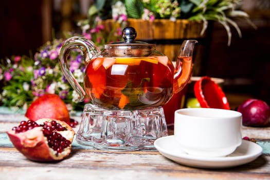 red fruit tea with pomegranate and white cup on the table.