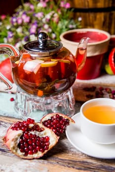 red fruit tea with pomegranate and white cup on the table.