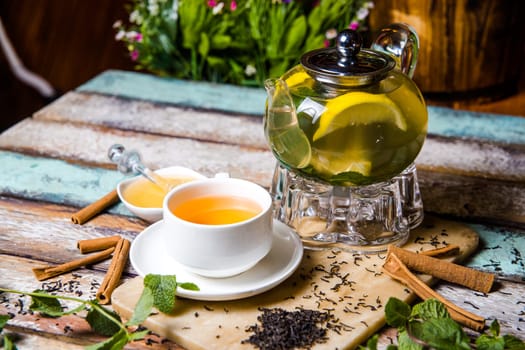 green tea with lemon and cinnamon on a wooden background.