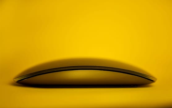 Modern tech wireless computer mouse on a yellow background