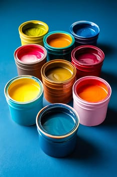 Group of colorful paints on blue surface. Generative AI.