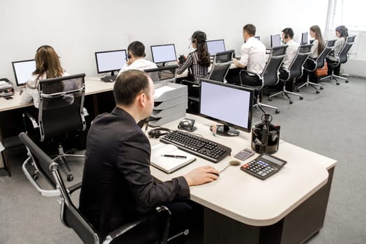 office workers at work on computers in the workplace.