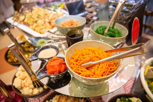 spicy carrots with sauce, ginger and nori on a glass table