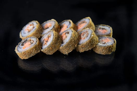 baked japanese rolls on a black background.