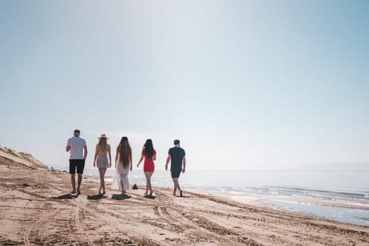 company of young people walking along the shore at dawn