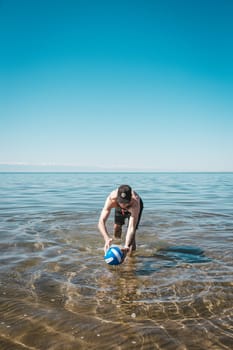 guy with a volleyball ball at sea on a summer day.