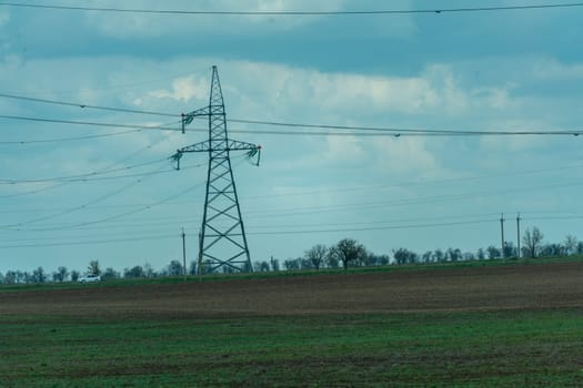 High voltage towers with sky background. Power line support with wires for electricity transmission. High voltage grid tower with wire cable at distribution station. Energy industry, energy saving.