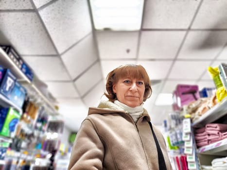 Middle-Aged Woman Shopping for Care Products at a Cosmetics Store. A woman browsing care products in well-stocked cosmetics aisle