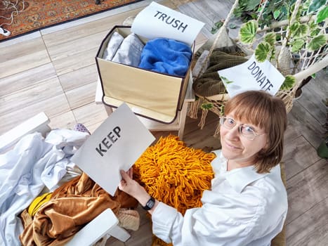 Middle-Aged Woman Sorting Belongings With KonMari Method. Mature woman categorizes items into keep and discard piles