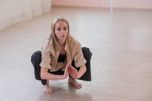 Caucasian woman dancing contemporary on the floor in a ballet class