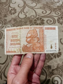 A close-up of a Fifty Billion Dollars Zimbabwean banknote. The banknote features the image of the balancing rocks of Matopos on the front.
