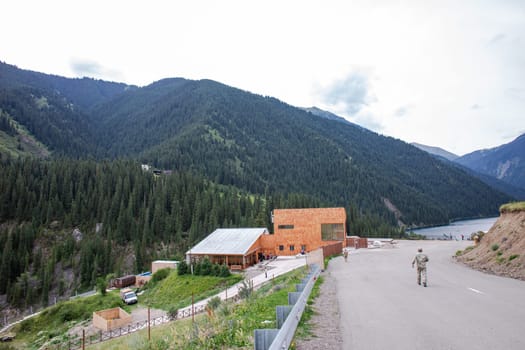 A long and winding road curves through the valley, with a house in the distance and a mountain in the background.