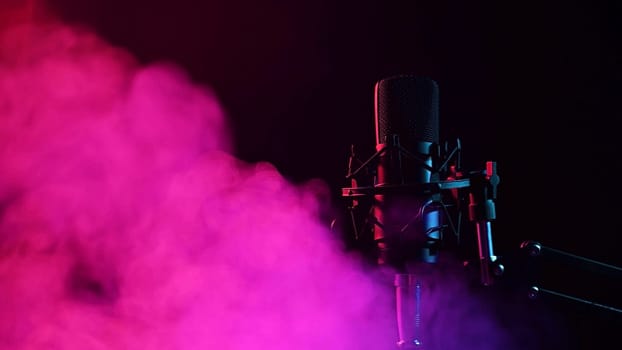 Professional microphone in pink smoke on a black background