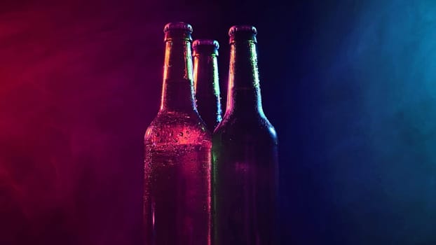 Three bottles of beer spinning in a blue-pink mist