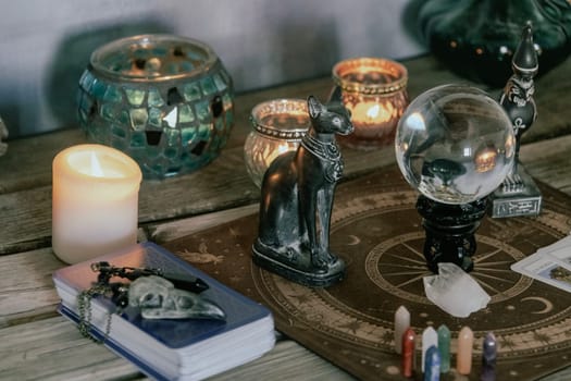 An atmospheric setting featuring a crystal ball, Egyptian cat statues, candles, and crystals, creating a mystical ambiance