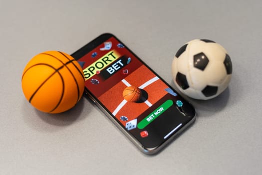smartphone with application for sport bets and a basketball ball, concept of online bets.