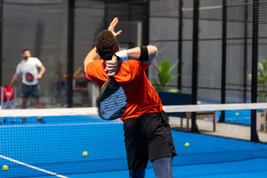 unrecognizable padel player playing padel in a padel court indoor behind the net. High quality photo