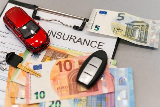 Top view of car insurance claim form with car key and car toy on desk. High quality photo
