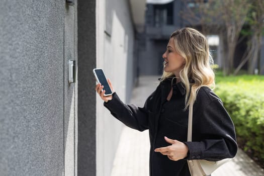 Smiling woman setting home security system with help of mobile application. High quality photo