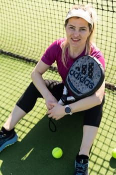 Ukraine Kyiv, March 31 2024. A girl in sportswear is training on a paddle tennis court. Concept of women playing paddle. High quality photo