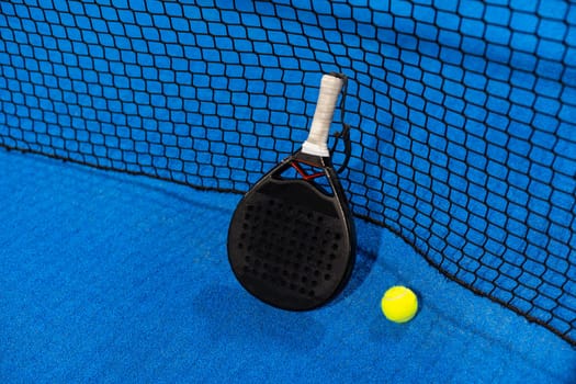 paddle tennis racket and balls on the blue paddle court. High quality photo