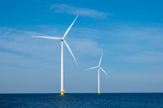 Three colossal wind turbines stand tall and majestic in the vast expanse of the ocean, harnessing the powerful energy of the wind to generate electricity. copy space, green energy in the Netherlands