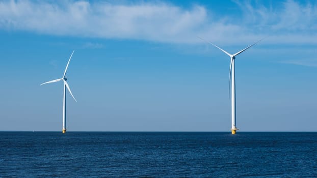 Two wind turbines stand tall in the middle of the ocean, harnessing the power of the wind to generate renewable energy for the Netherlands Flevoland region. windmill turbines at sea