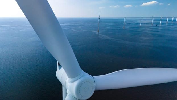 A mesmerizing aerial perspective showcases the expansive wind farm in the Dutch waters of Flevoland, where elegant windmill turbines harness renewable energy.