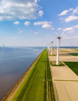 A mesmerizing aerial view of a row of majestic wind turbines spinning gracefully in the vast landscape of Flevoland, Netherlands.