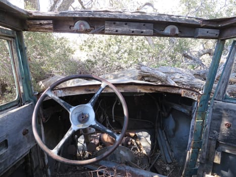 Driver View of Steering Wheel Inside an Abandoned Old Car in the Desert. High quality photo
