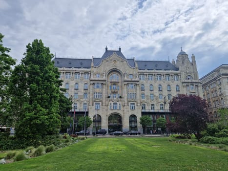 BUDAPEST/HUNGARY - 2023-05-06: Gresham Palace, a magnificent example of Art Nouveau architecture, stands proudly on the banks of the Danube River in Budapest. Its elegant facade, adorned with intricate details and sculptures, reflects the grandeur of its history as a luxury hotel. Against the backdrop of the iconic Chain Bridge, Gresham Palace is a timeless symbol of Budapest's architectural splendor.