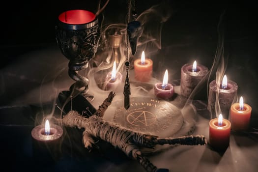 A haunting occult setup featuring a pendulum, mystical symbols, candles, a voodoo doll, and a ritual goblet amidst swirling smoke