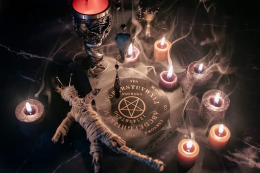 A haunting occult setup featuring a pendulum, mystical symbols, candles, a voodoo doll, and a ritual goblet amidst swirling smoke