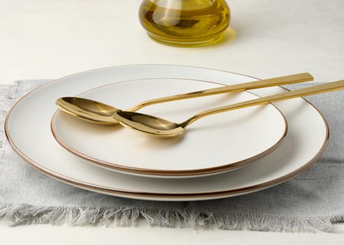 Empty round plates and two golden salad spoons on the table