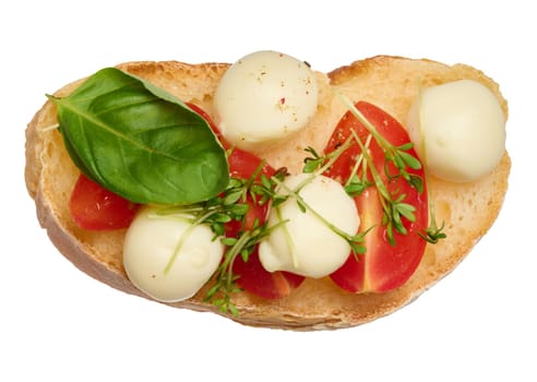 Round mozzarella, cherry tomatoes and microgreens on a piece of white bread, top view