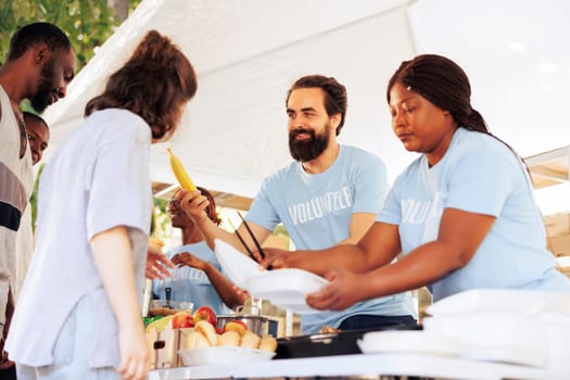 Hunger relief initiative providing essential items to the hungry and less fortunate. Friendly humanitarian aid team distributes food, offering support to poor, homeless people and refugees.