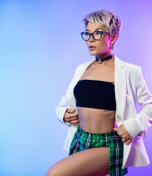 Sexy girl with glasses and a white jacket with a plaid skirt in neon light on a background of copy paste