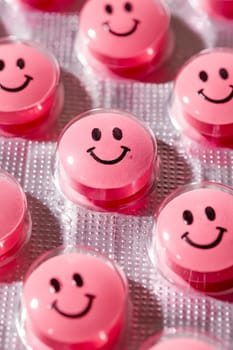 A row of pink pills with smiling faces on them. The pills are arranged in a row and are all the same color. Generative AI