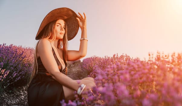 Close up portrait of young beautiful woman in a white dress and a hat is walking in the lavender field and smelling lavender bouquet.